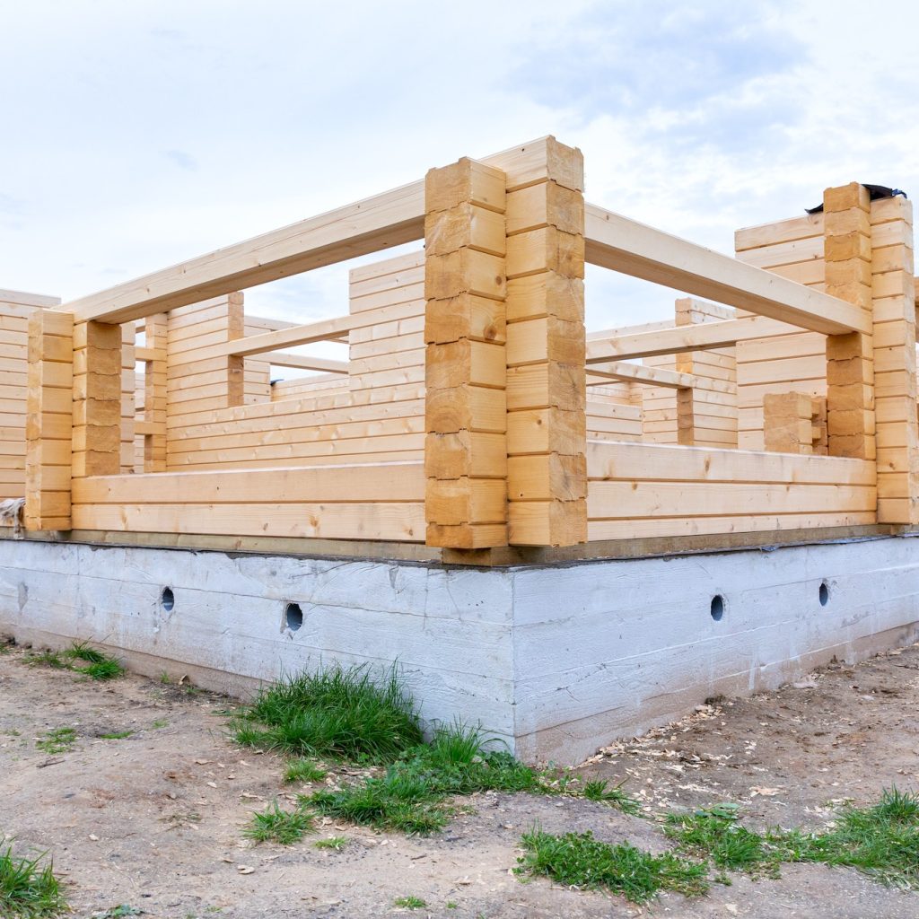 Construction of a wooden house on a cement base, foundation.